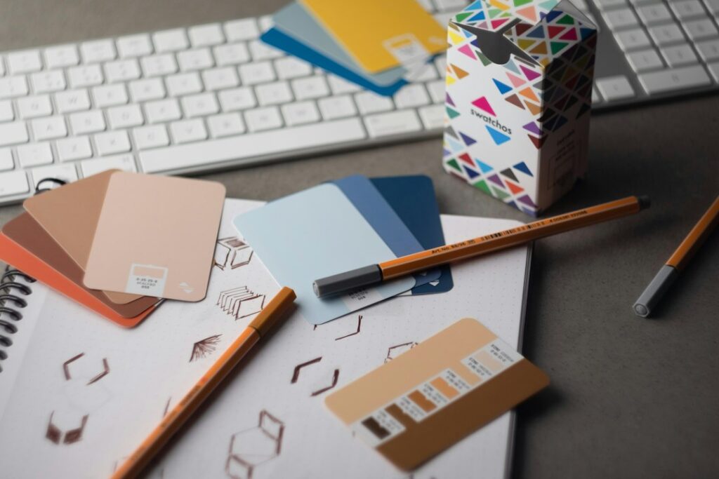 Mesa de designer com amostras de cores, representando a criação de artes e cartazes para igrejas no Canva