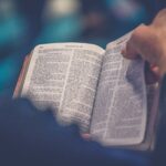 Página da Bíblia sendo aberta, representando o ensino de Deuteronômio 6 sobre amar a Deus e guardar a Palavra