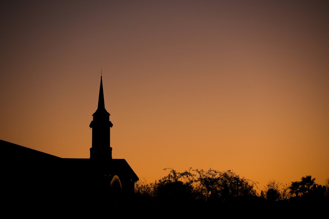 Igreja em silhueta diante do céu ao entardecer, imagem de esperança e vigilância