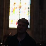 Pessoa em silêncio dentro de uma igreja iluminada por vitrais