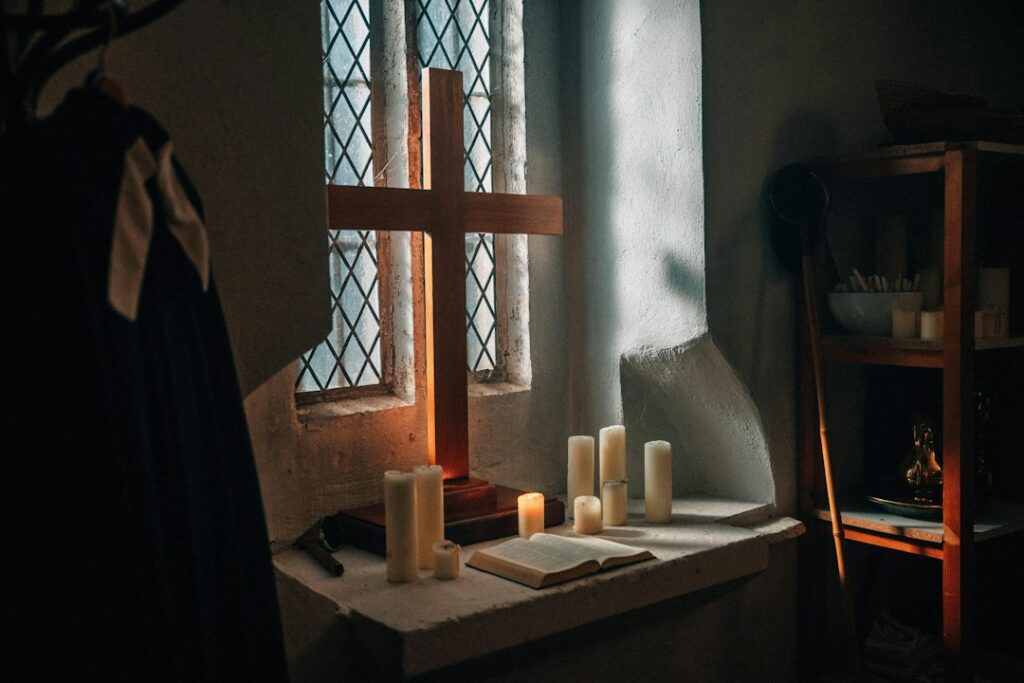 Bíblia, cruz e velas em ambiente de estudo, imagem de destaque da Lição 3 CPAD Jovens sobre a humildade e a obediência de Jesus Cristo