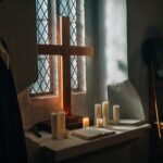 Bíblia, cruz e velas em ambiente de estudo, imagem de destaque da Lição 3 CPAD Jovens sobre a humildade e a obediência de Jesus Cristo