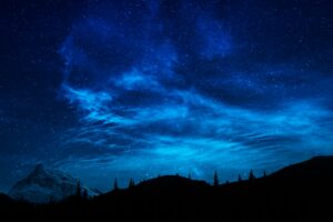 Céu noturno estrelado sobre paisagem de montanhas, simbolizando os astros que resplandecem em Filipenses 2.15