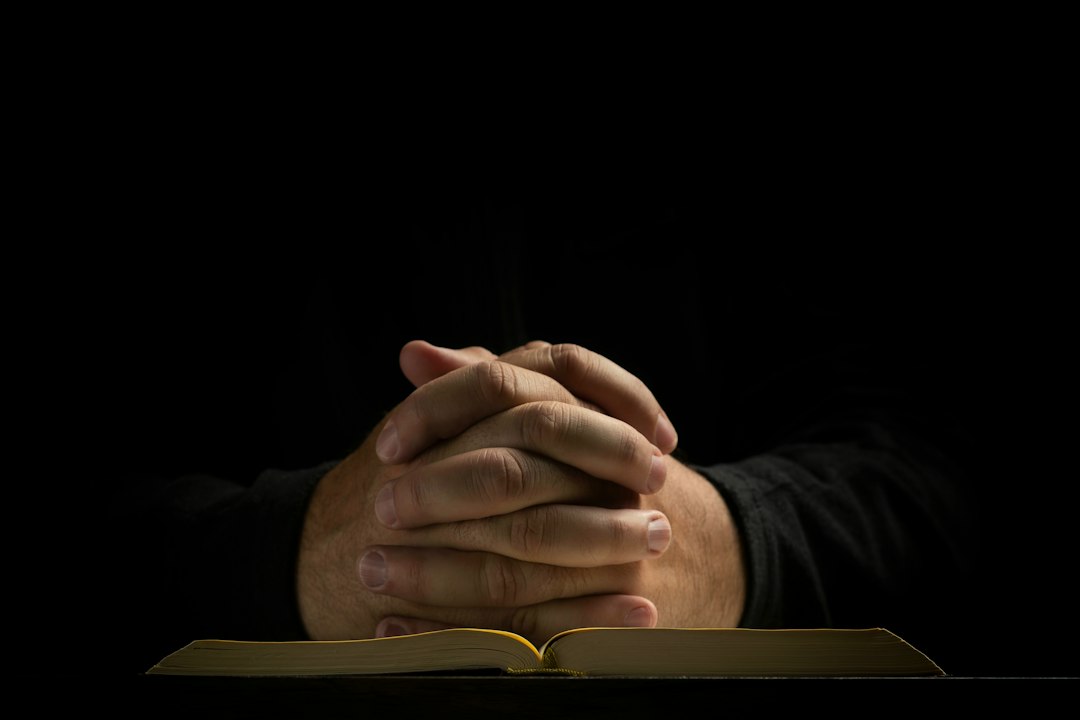 Mãos postas em oração sobre a Bíblia, ilustrando a confiança em Deus e a paz que guarda o coração conforme Filipenses 4.6-7.